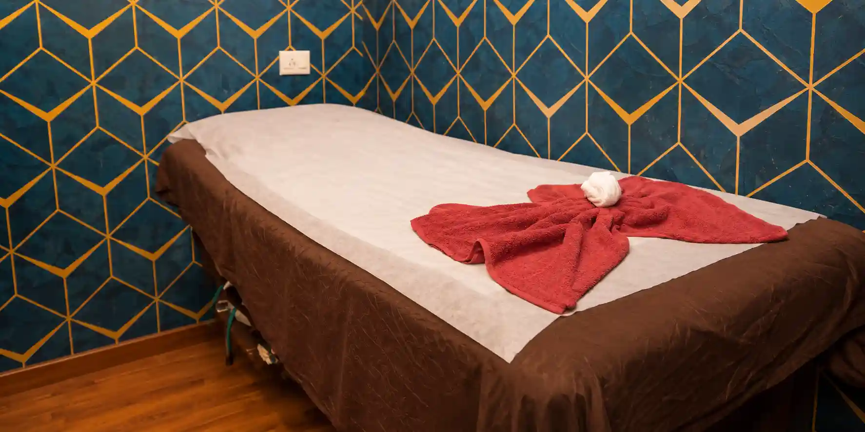 Massage table with a folded towel, blue and gold walls